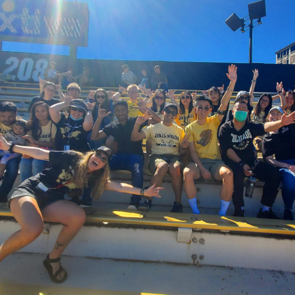 Photo of international students and ISSS staff in the bleachers of football game