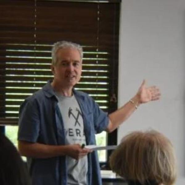 Photo of instructor teaching and pointing to white board
