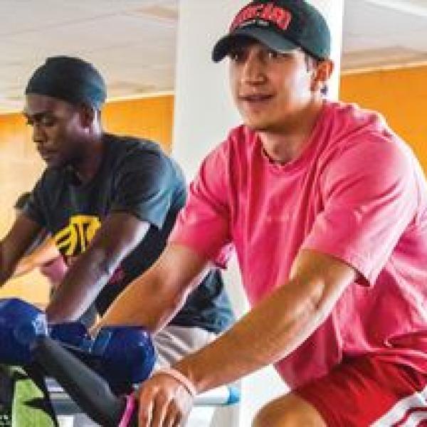 Photo of two men riding stationary bikes