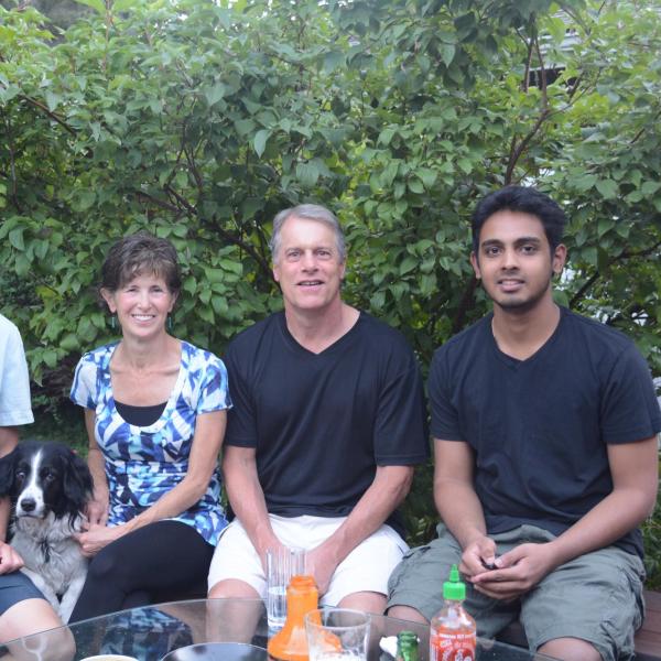BFIS family in backyard on a bench with their BFIS student
