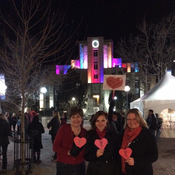 Student and BFIS family on pearl street holding paper hearts