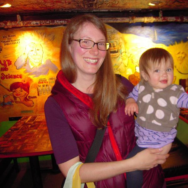 BFIS board member with young daughter in front of restaurant mural