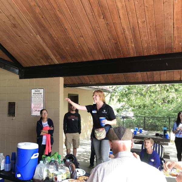 ISSS staff standing on picnic table to make announcements as others gather around