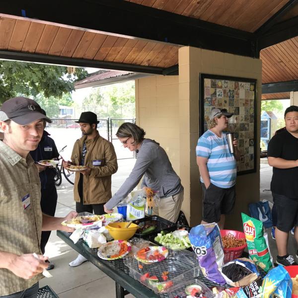 People hanging out around the food table