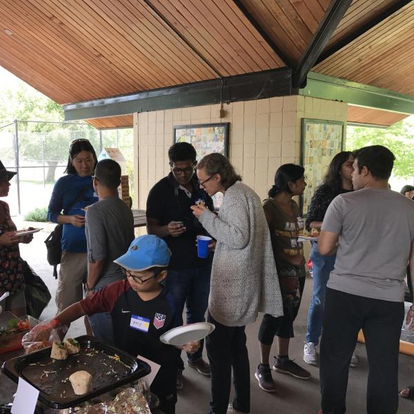 People mingling under the shelter as a child grabs food