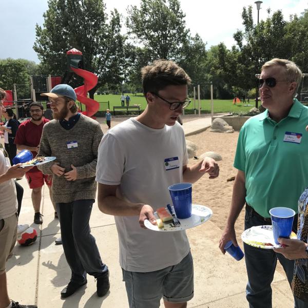 BFIS student talking to BFIS family with plates in hand
