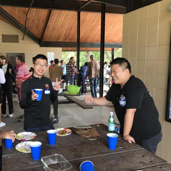 Three students standing around a table smiling