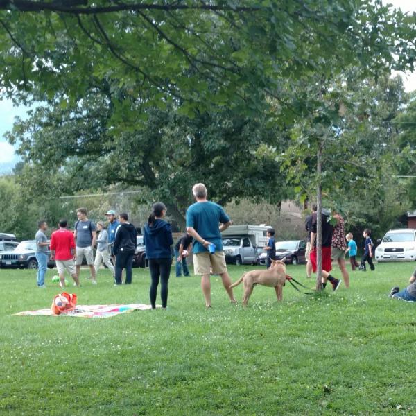Grassy field with people watching a soccer game