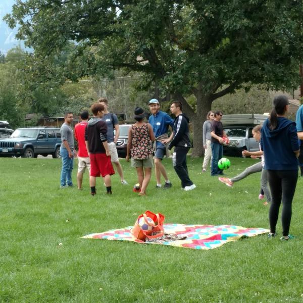 Group of people playing soccer on grassy field