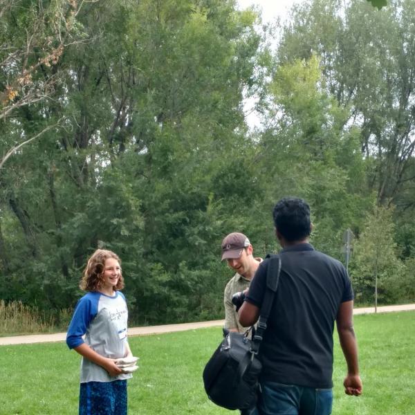 Three people playing cornhole