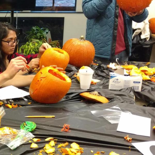 Two students carving pumpkins intently