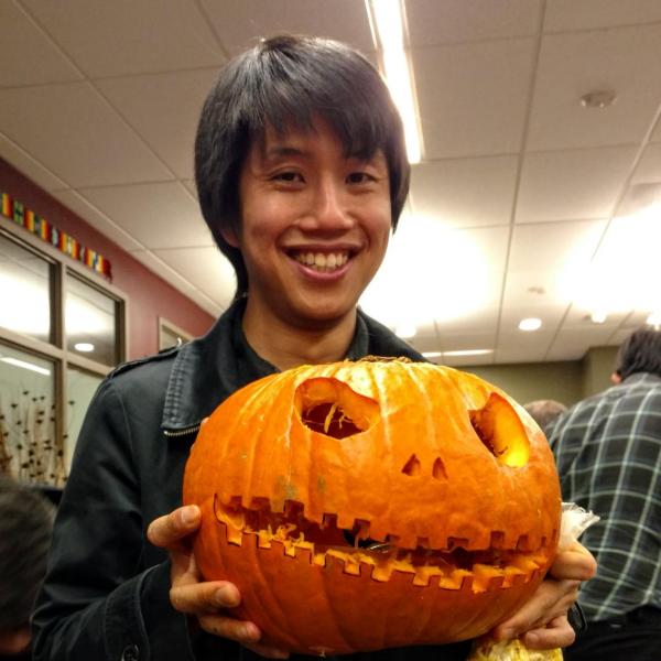 Student smiling with pumpkin carved like Jack from Nightmare Before Christmas