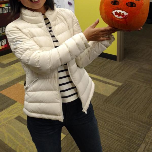Student smiling with pumpkin painted like a devil