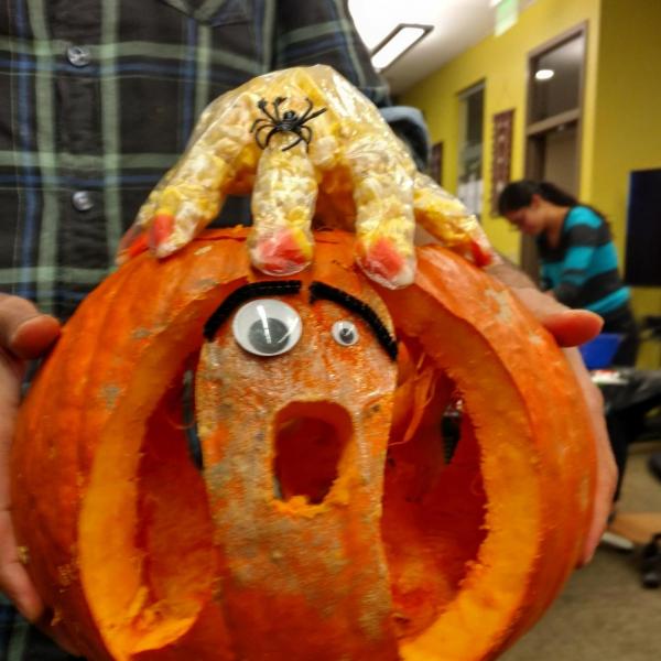 Pumpkin with funny pipe cleaner eyebrows and popcorn hand on top