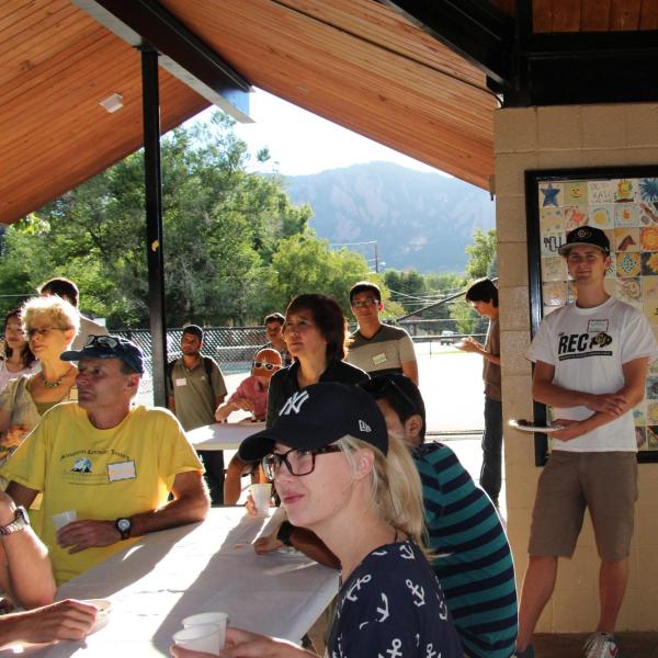 Several BFIS members facing one direction under picnic shelter