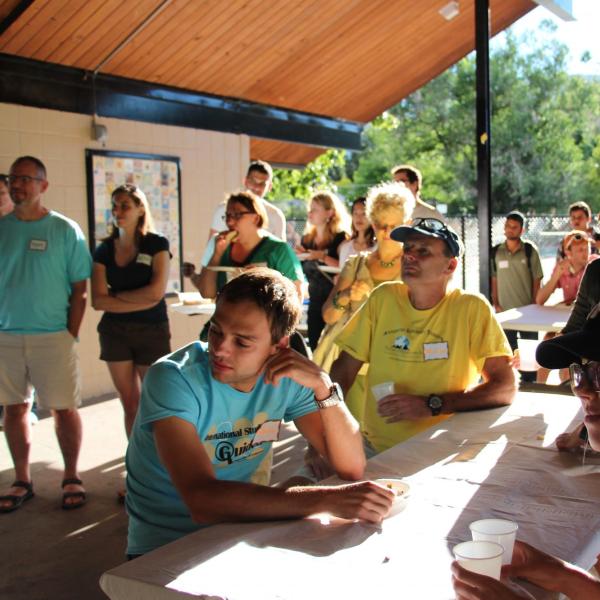 Several BFIS members facing one direction under picnic shelter