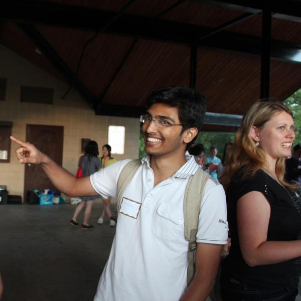 One smiling student pointing at another smiling student