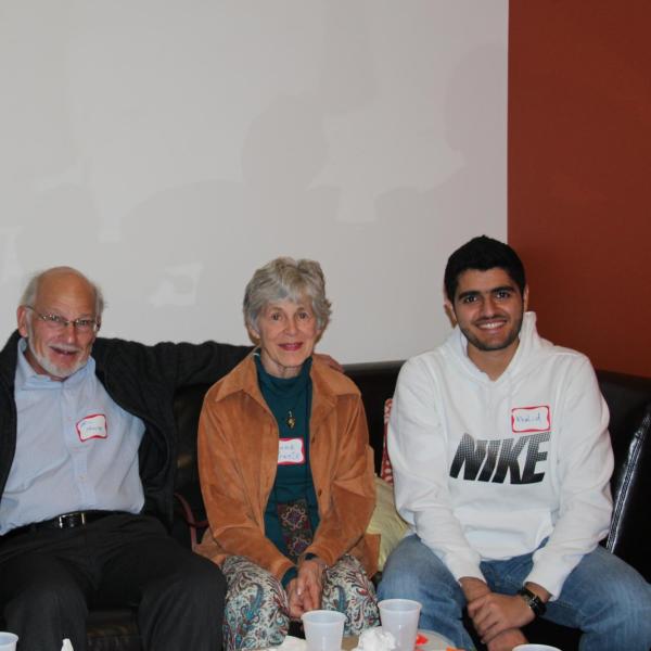 Two BFIS students sitting on couch with their BFIS family