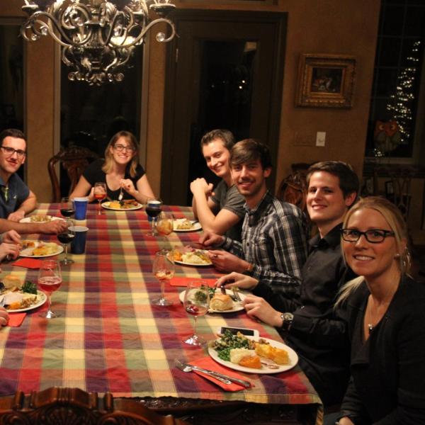 BFIS students and family sitting around the table for Thanksgiving meal