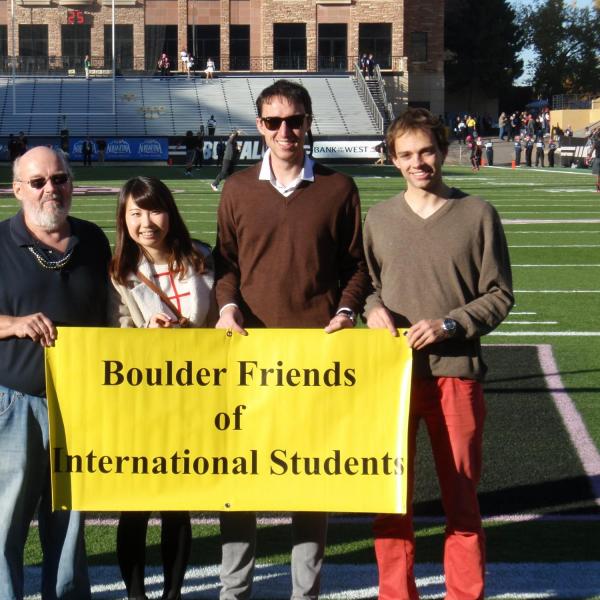 BFIS family and students on football field holding BFIS sign