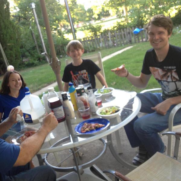 BFIS student eating at patio table with BFIS family