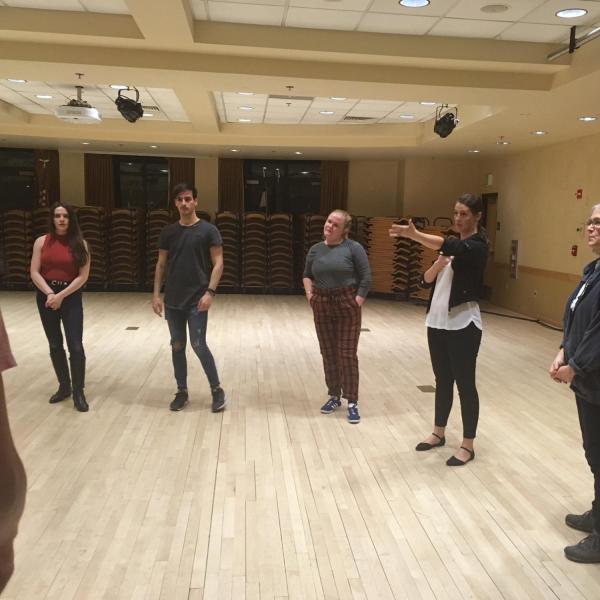 People in a circle listening to Salsa dance instructions