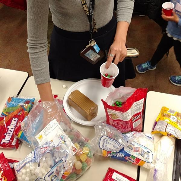 Student grabbing candy supplies for her house