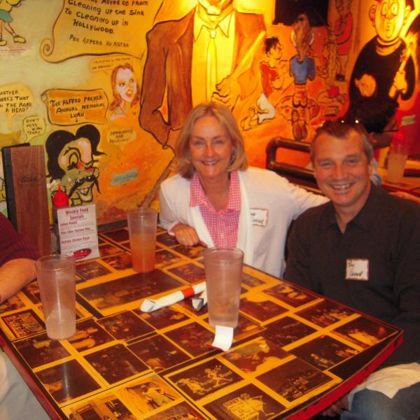 Three BFIS members smiling from restaurant booth