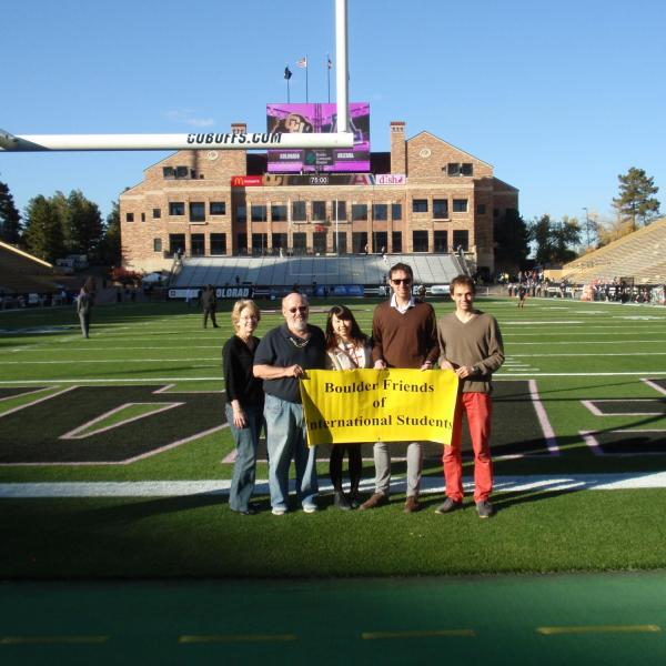 BFIS family and students on football field holding BFIS sign