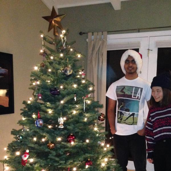 Two BFIS students standing next to Christmas tree