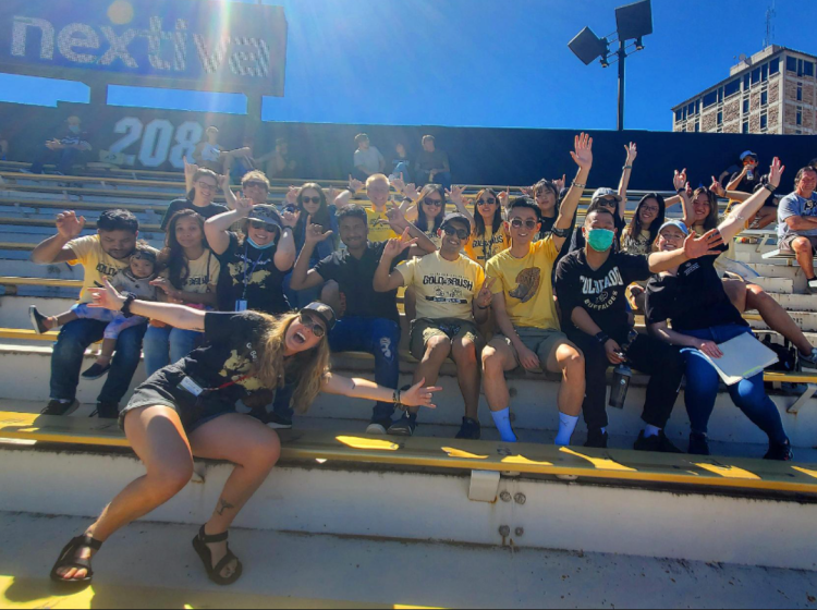 Photo of international students and ISSS staff in the bleachers of football game