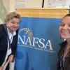ISSS staff Chris Hertel and Amrine Obermueller posing near NAFSA sign