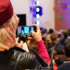 Person filming performers on stage at the International Festival