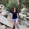 Erica Coffelt standing on rocks with stream in background