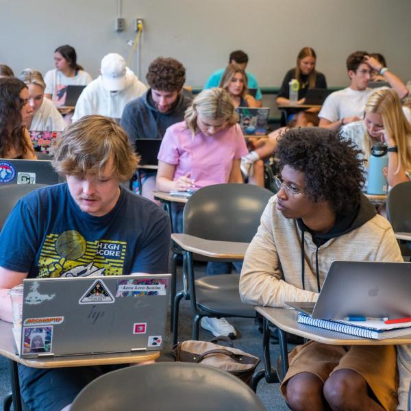 Students sitting at their desks in a Jewish Studies classroom discussing work