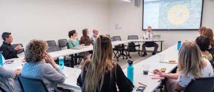 Attendees watch Jacob Flaws as he presents his summer research from the Post-Holocaust American Judaism during a symposium in fall 2018