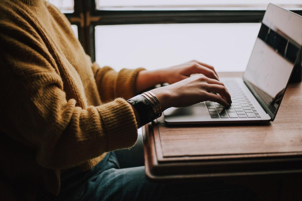 Close up shot of a person working on a laptop.