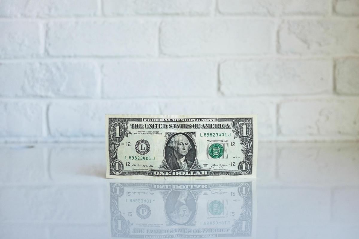 Dollar bill balancing on its edge.