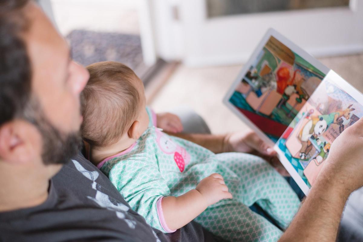 Father reading to newborn child.