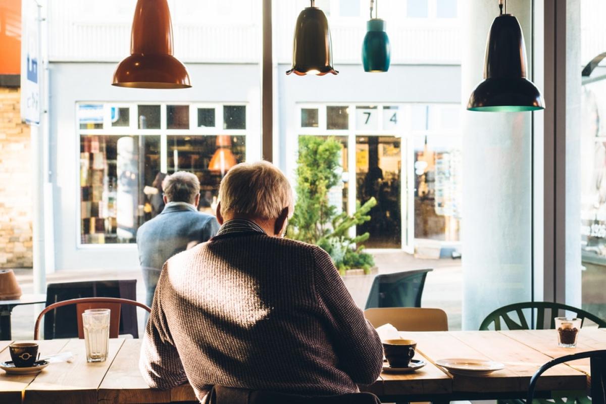 Older man sitting in a coffee shop.