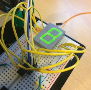 seven segmant led being lit on breadboard with wires