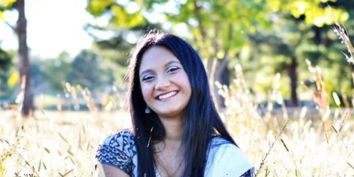 Picture of Dipa smiling in a field.