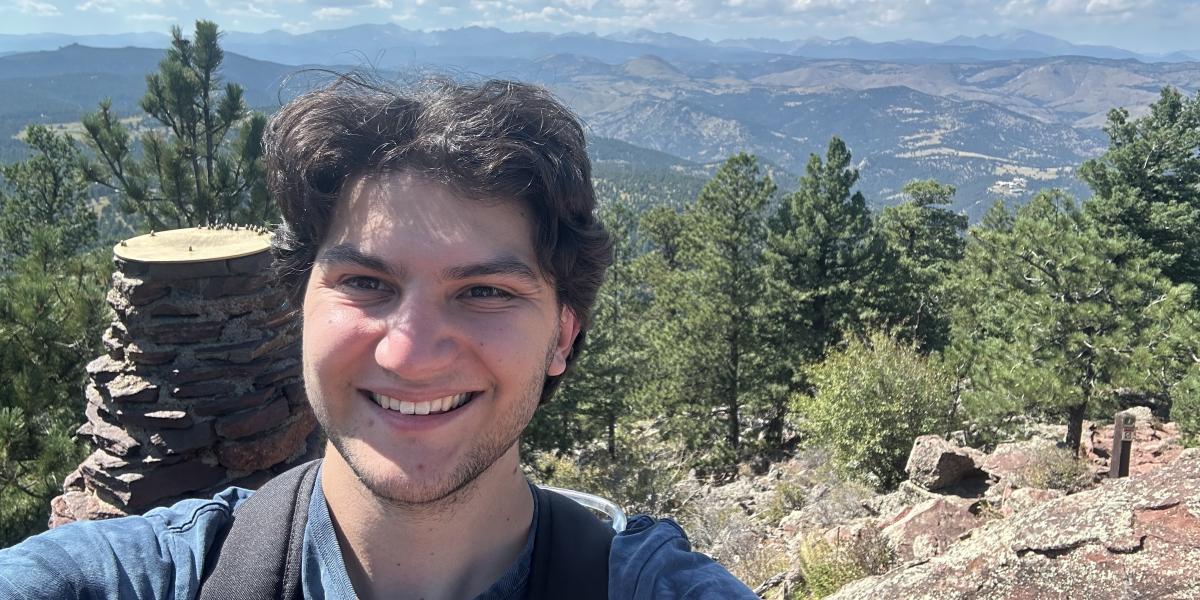 Dylan smiling in front of trees