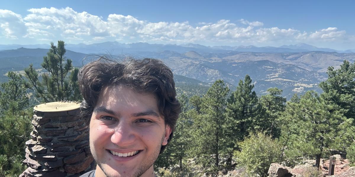 Dylan smiling in front of trees