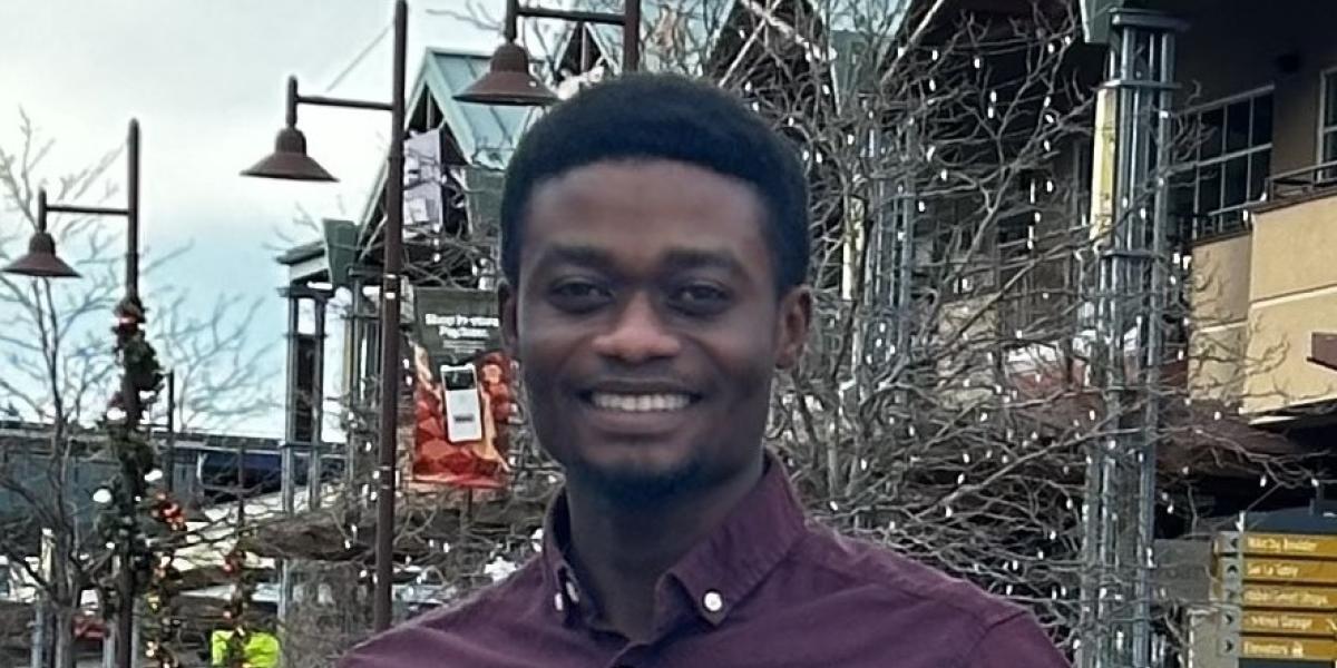 Image of Samson standing in front of shopping center in a purple shirt