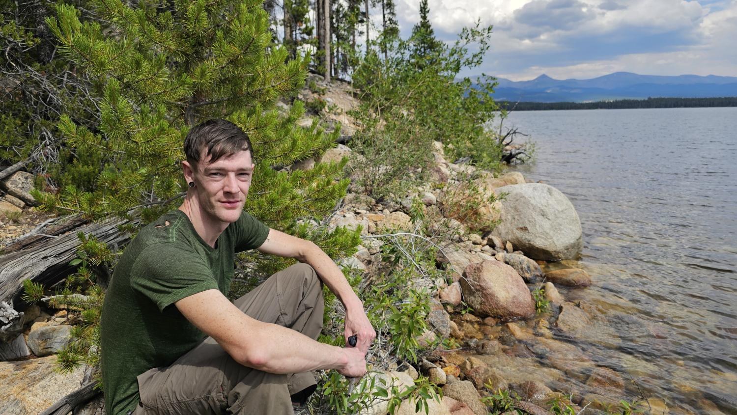 A man sitting on a rocky shore