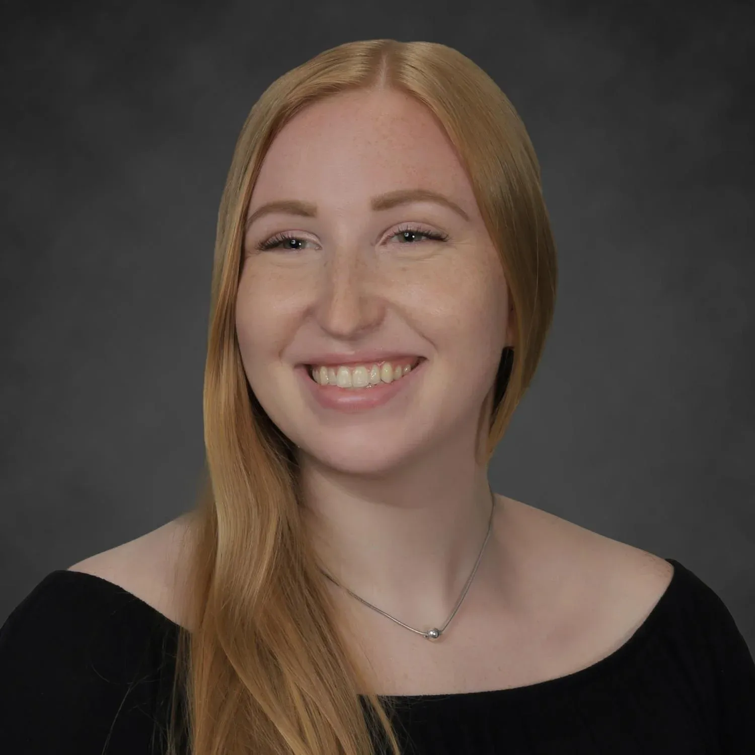 A photo of a woman smiling at a camera from a professional shoot.