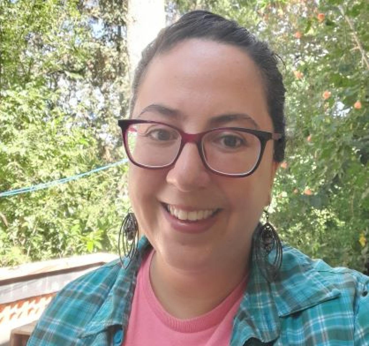 Headshot of Silvia, with plants behind her