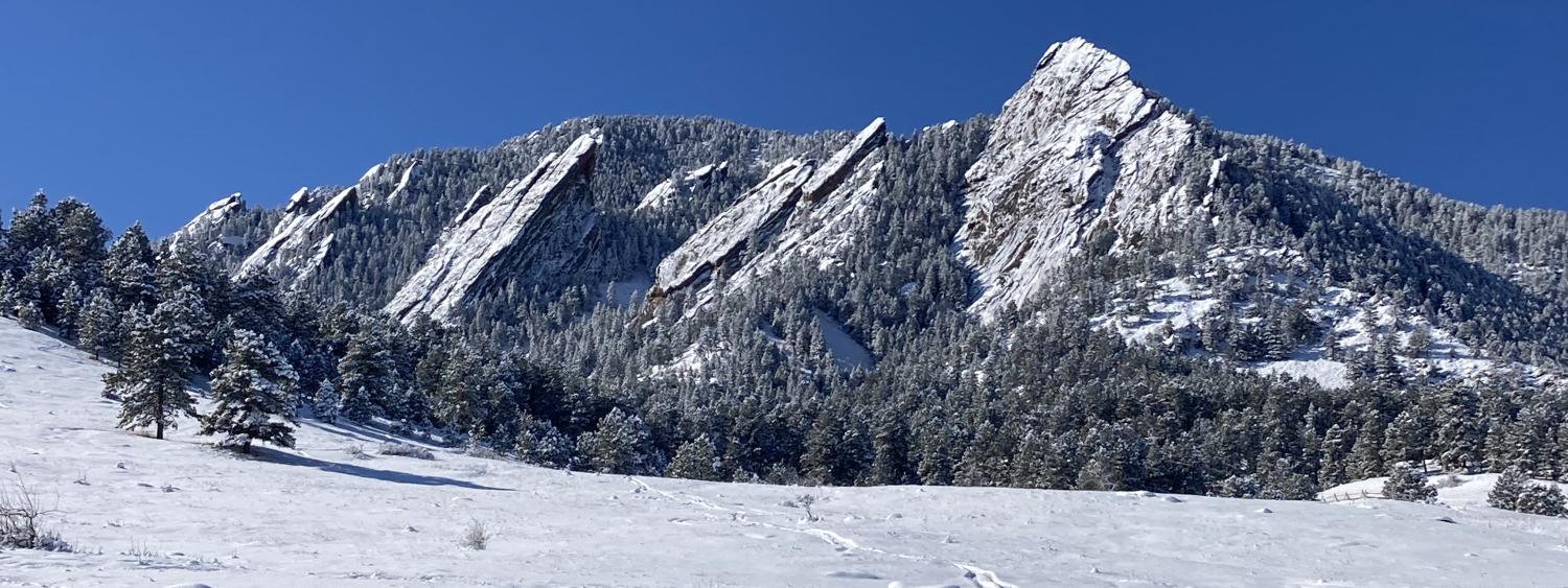 Image of rock faces covered in snow (the flatirons in Boulder, Colorado)