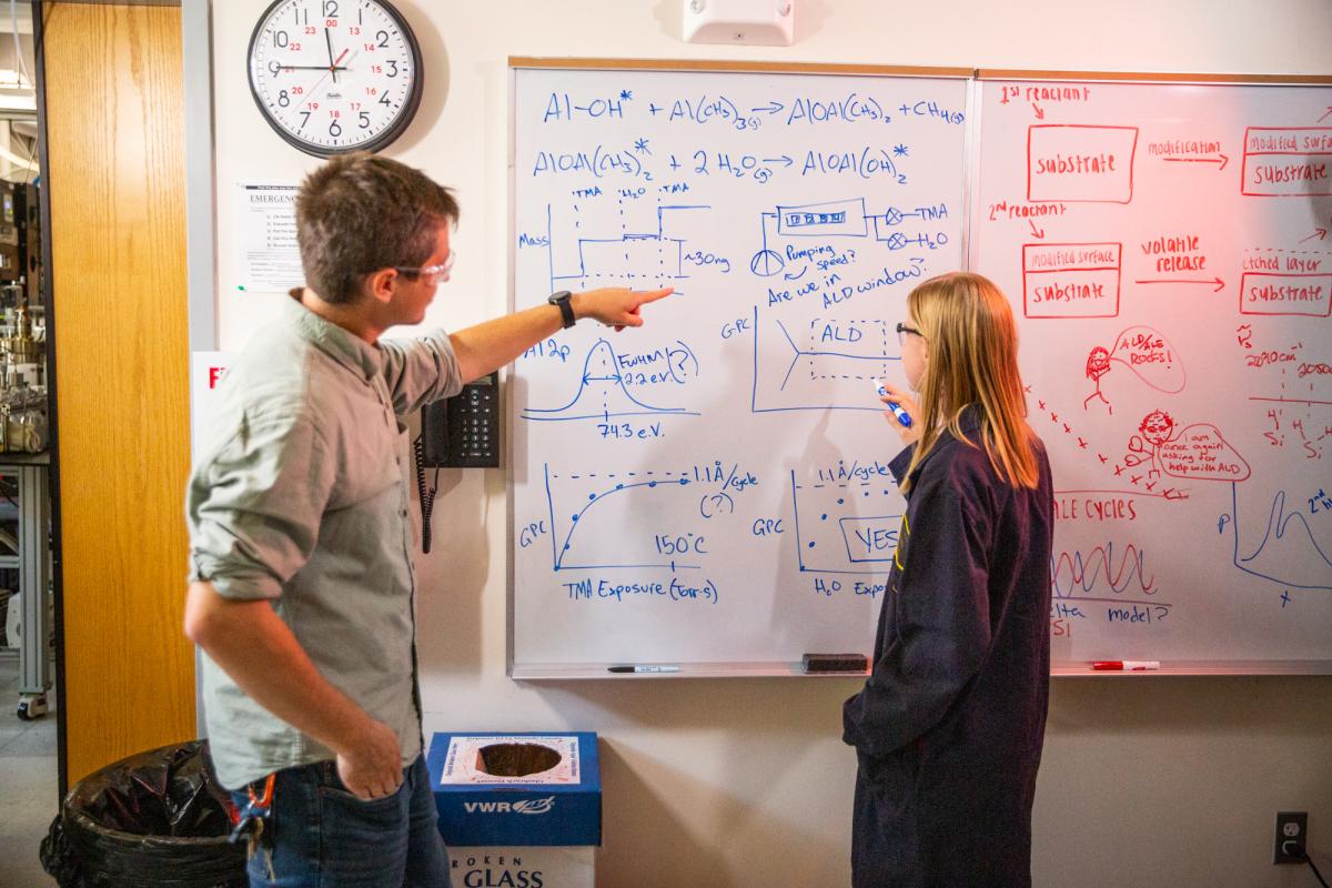 Jessica Murdzek & Austin Cano on the Whiteboard in the Laboratory; University of Colorado at Boulder, Steven M. George Research Group